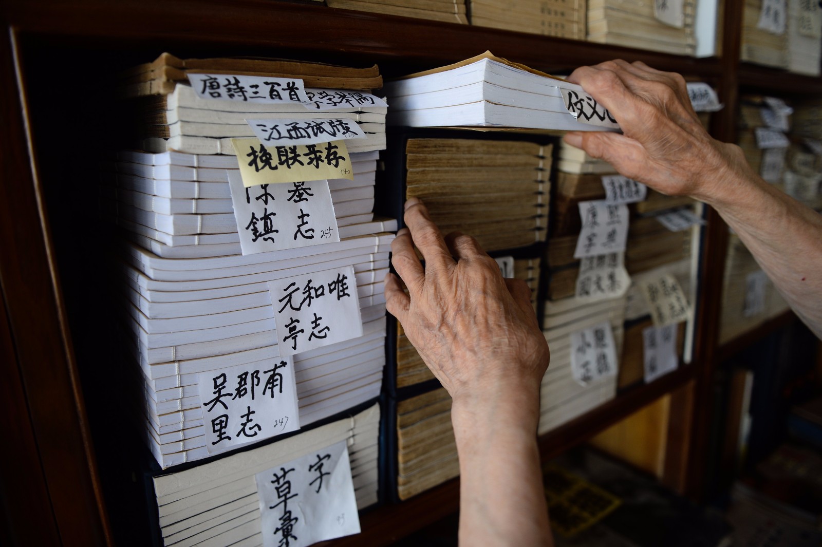  7月18日，江澄波老人在“文学山房”旧书店整理线装书籍。 
