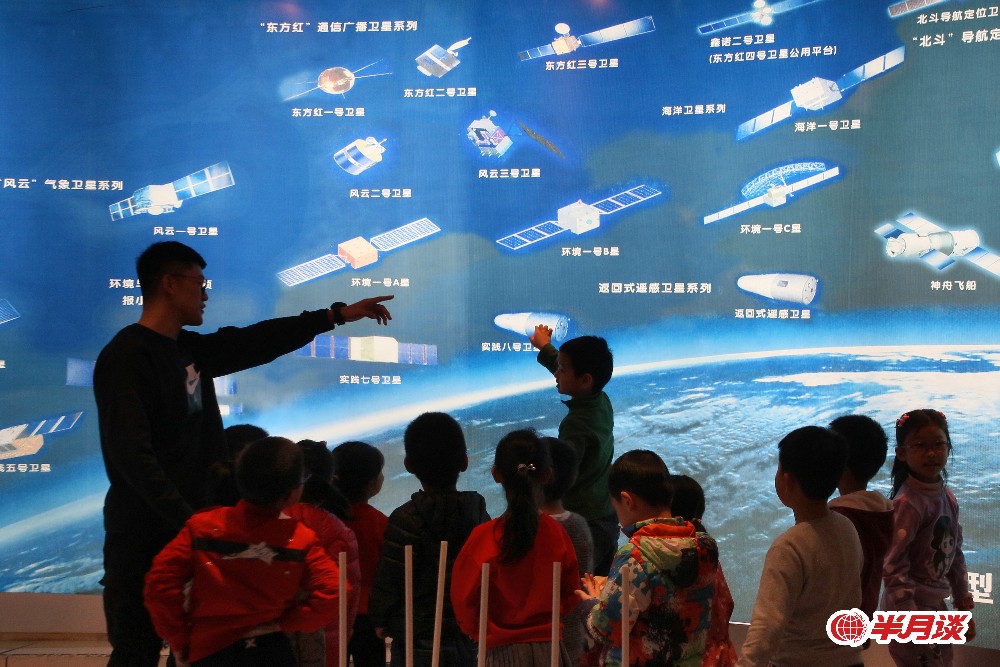 4月21日，山东航天电子技术研究所的工作人员为小朋友讲解“中国卫星飞船型谱图”。当日，位于山东烟台的山东航天电子技术研究所举行开放日活动。不少市民来到航天科技展厅，观看各种航天装备模型和空间技术图示，学习航天知识，迎接4月24日“中国航天日”的到来。新华社发（唐克 摄）